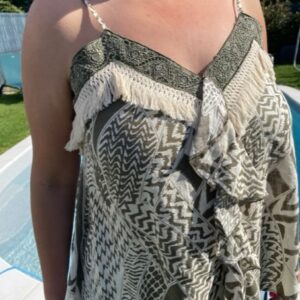 Top femme ethnique à fines bretelles avec broderies décoratives et franges, modéle léger au style bohème chic pour l'été.