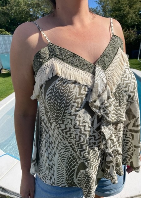 Top femme ethnique à fines bretelles avec broderies décoratives et franges, modéle léger au style bohème chic pour l'été.
