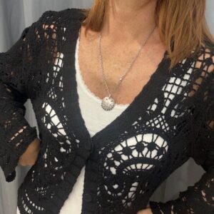 Gilet femme ajouré noir en maille travaillé, coupe féminine avec boutons sur le devant. Disponible chez Malou&Co, vêtements pour femmes à La Rochelle.