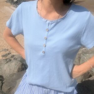 T-shirt femme Nolan à boutons avec col dentelé, coupe fluide et manches courtes, style chic et féminin pour un look élégant et tendance au quotidien.