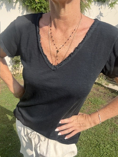 Top femme à manches courtes avec col V et finitions franges, style bohème chic, idéal pour une tenue estivale et élégante et décontractée