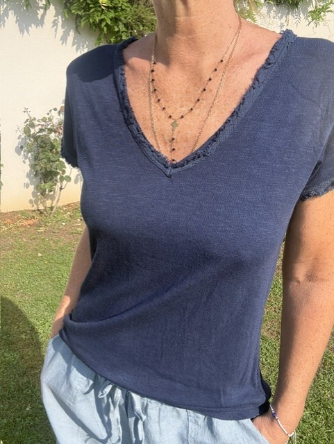 Top femme à manches courtes avec col V et finitions franges, style bohème chic, idéal pour une tenue estivale et élégante et décontractée