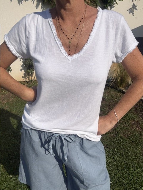 Top femme à manches courtes avec col V et finitions franges, style bohème chic, idéal pour une tenue estivale et élégante et décontractée