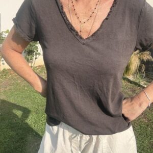 Top femme à manches courtes avec col V et finitions franges, style bohème chic, idéal pour une tenue estivale et élégante et décontractée