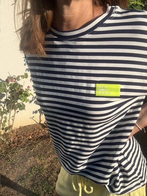 T-shirt femme Nino marinière bleu marine et blanc à manches courtes, col rond, coupe confortable, patch fantaisie sur la poitrine. Style casual pour le quotidien.