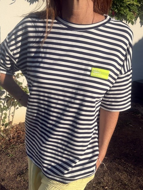 T-shirt femme Nino marinière bleu marine et blanc à manches courtes, col rond, coupe confortable, patch fantaisie sur la poitrine. Style casual pour le quotidien.